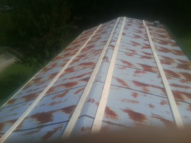 Rusted metal roof panels with new wood purlins before replacement — Storm Damage Roof Repair in New Haven by Roofing Brothers